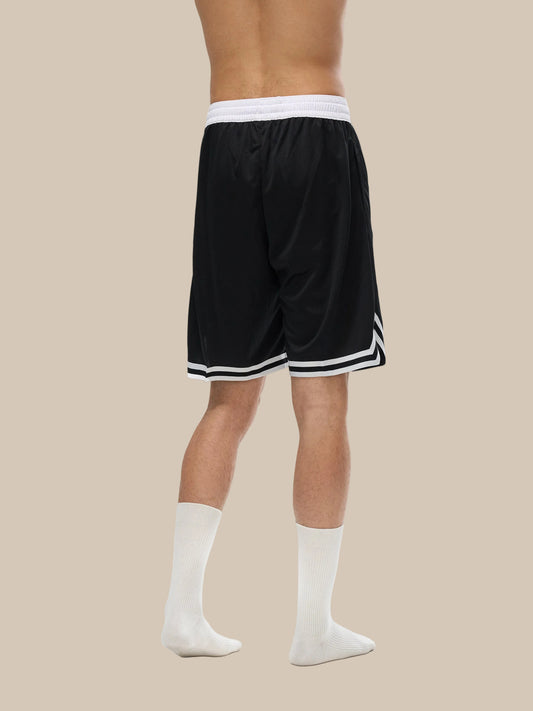Lower half of model wearing the sustainable Future-Homme activewear classic stripe trim basketball short in black back side view on a white background