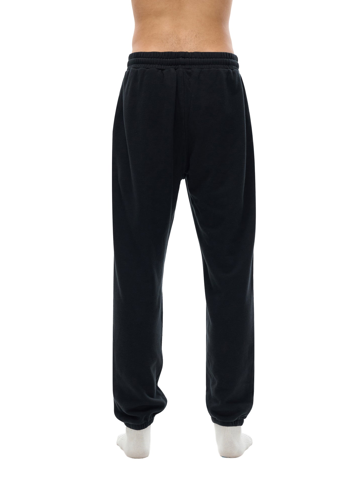 Lower half of model wearing sustainable 360 GSM Future-Homme daily uniform cotton fleece sweatpants backside in black on a white background.