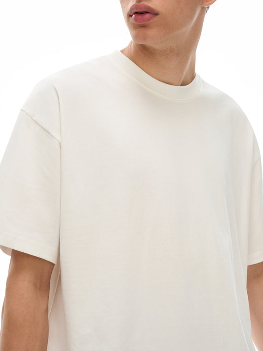 Model wearing the sustainable Future-Homme daily uniform loose cotton drop tee 230 GSM in apricot frontside on a white background