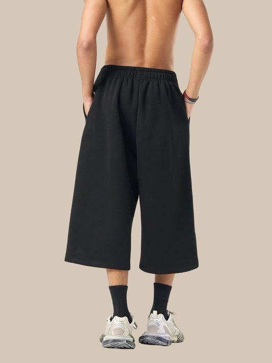 Person wearing black wide-leg pants on a white background