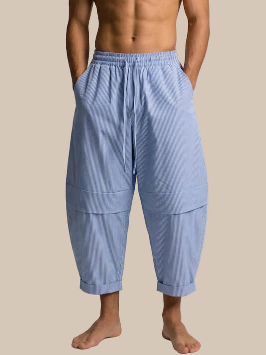 A male model wear a wide leg light blue barrel pant on a white background