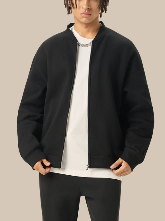 Person wearing a black bomber jacket over a white shirt on a white background
