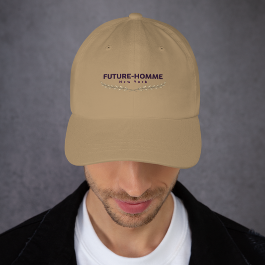 Beige cap with 'FUTURE-HOMME New York' logo worn by a person on a gray background