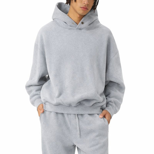 Male model wearing a heather gray hoodie lounge suit on a white background