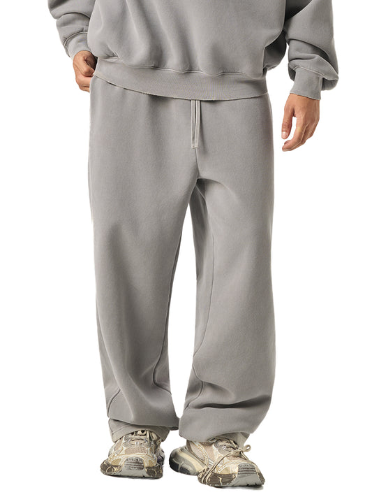 Person wearing a gray tracksuit with hiking shoes on a white background