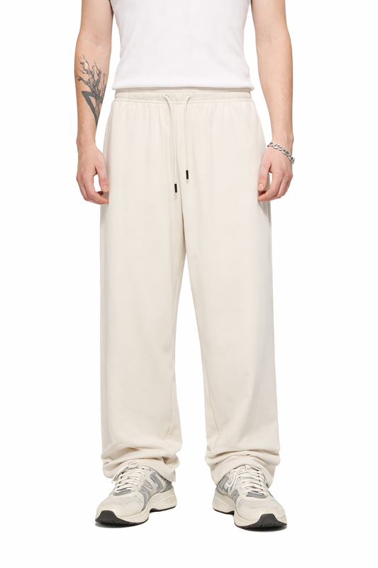 Person wearing cream-colored sweatpants on a white background