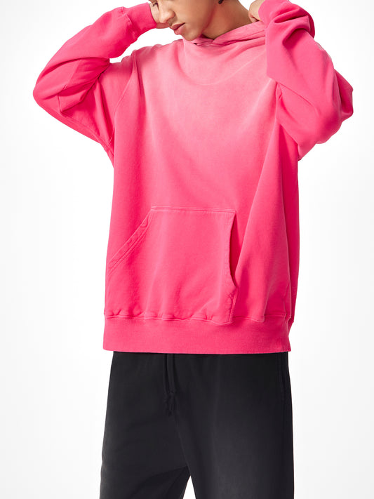 Model wearing a sustainable Future-Homme Ombre Hoodie with kangaroo pockets in pink frontside on a white background.