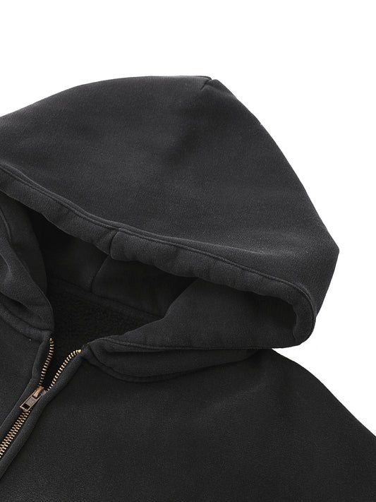 Close-up of a black hooded jacket with a zipper on a white background