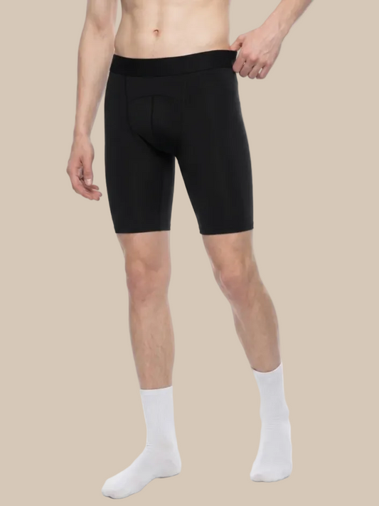 Person wearing black tight cycling shorts and white socks on a beige background