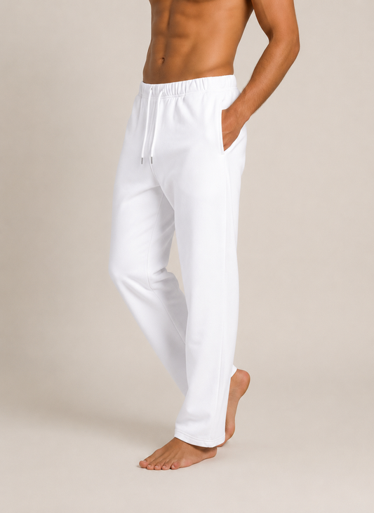 White men's lounge pants with an elastic drawstring waist and side pockets, shown on a model against a plain beige studio background.