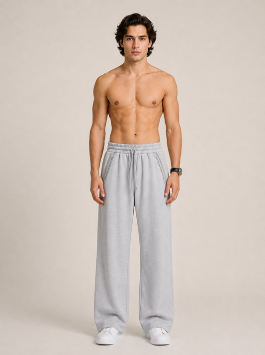 A model wearing light gray sweatpants on a beige background.