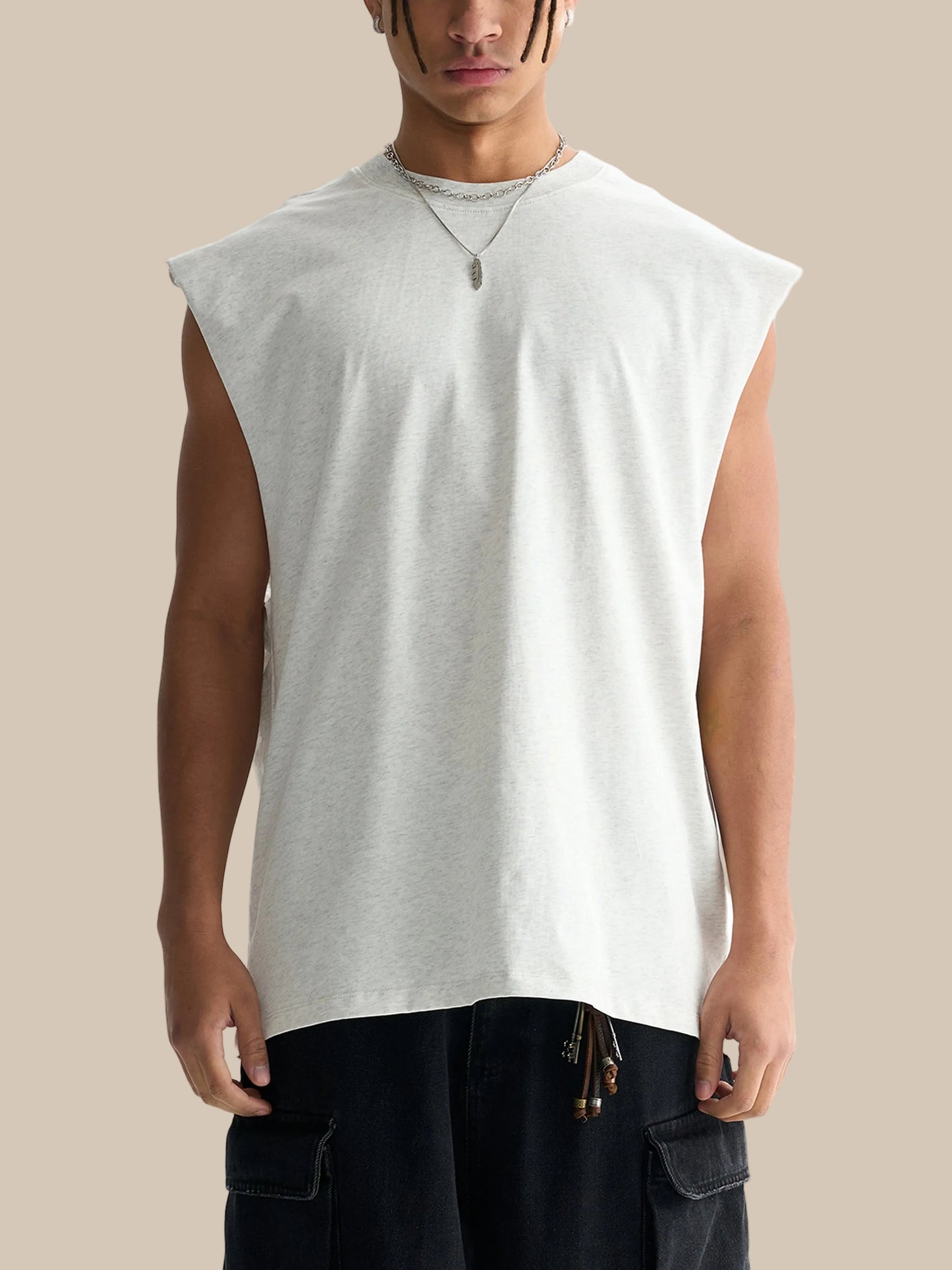 Man wearing a sleeveless white shirt and black pants on a white background