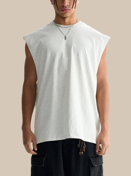 Man wearing a sleeveless white shirt and black pants on a white background