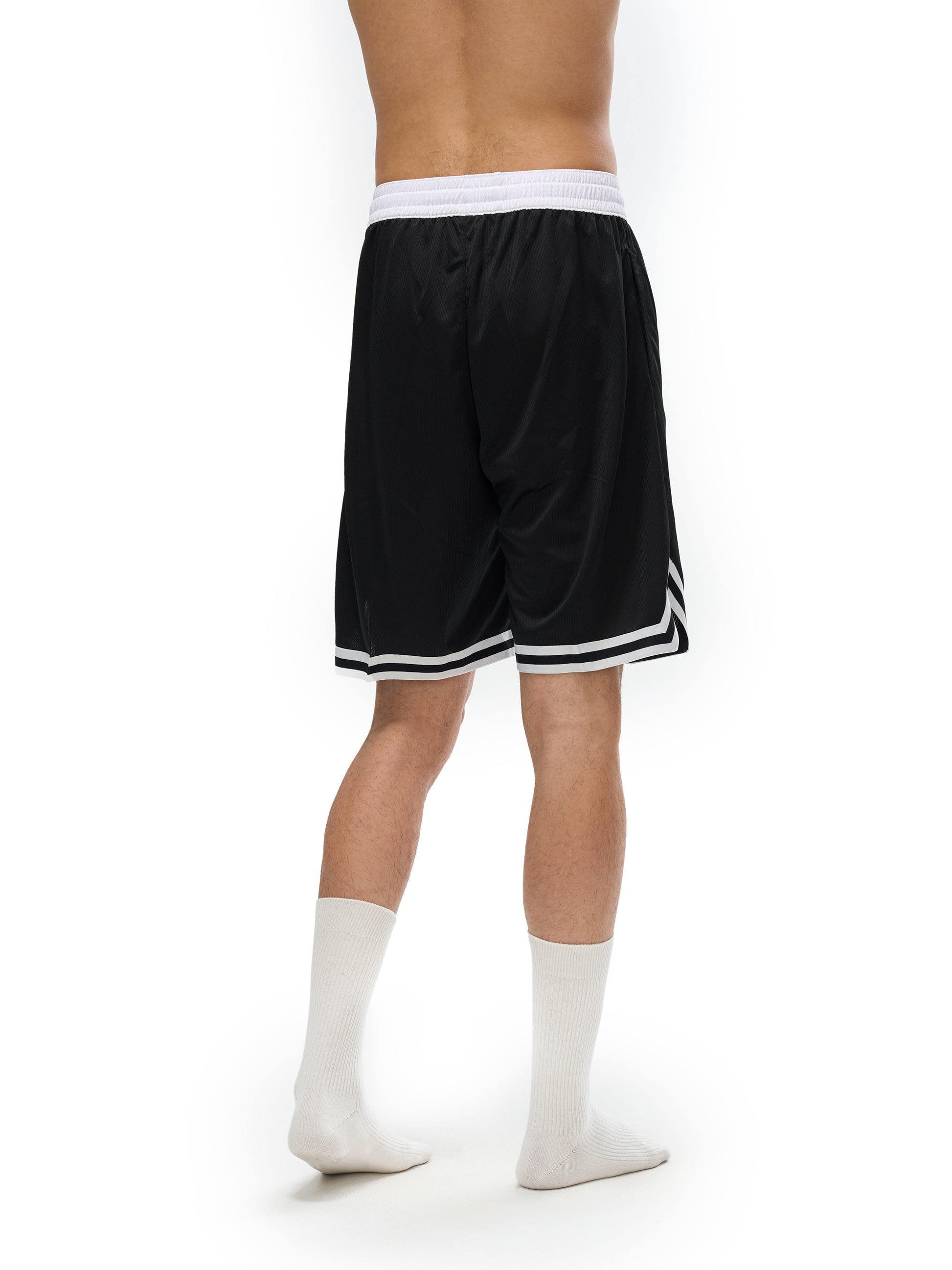 Lower half of model wearing the sustainable Future-Homme activewear classic stripe trim basketball short in black back side view on a white background