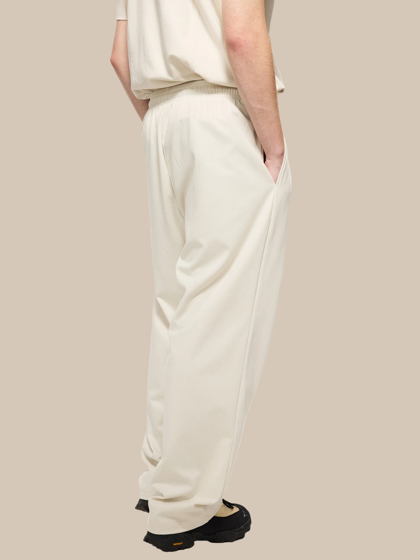 Person wearing beige pants on a white background