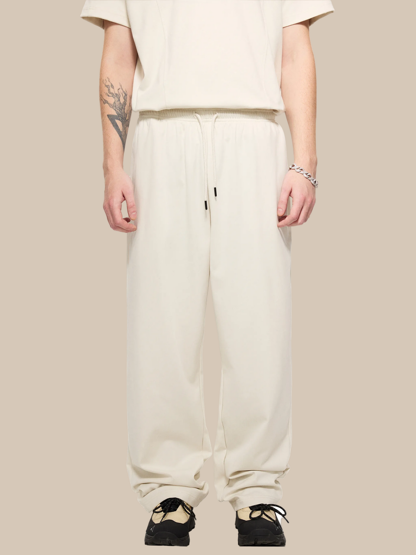 Person wearing beige sweatpants on a white background