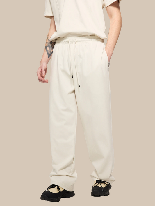 Person wearing beige sweatpants on a white background