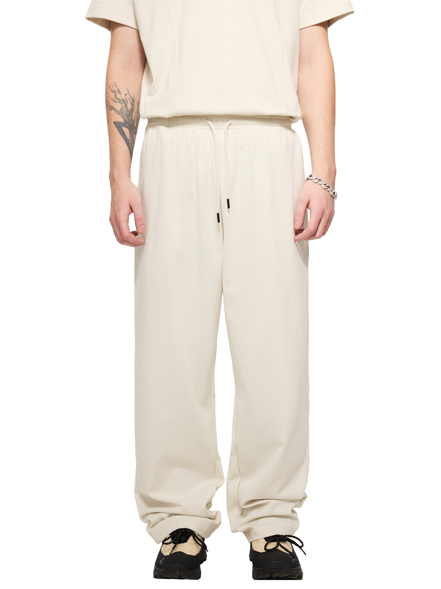 Lower half of a male model wearing a sustainable 240 GSM Future-Homme activewear mesh lined quick dry performance pants in grayish white front angle on a white background