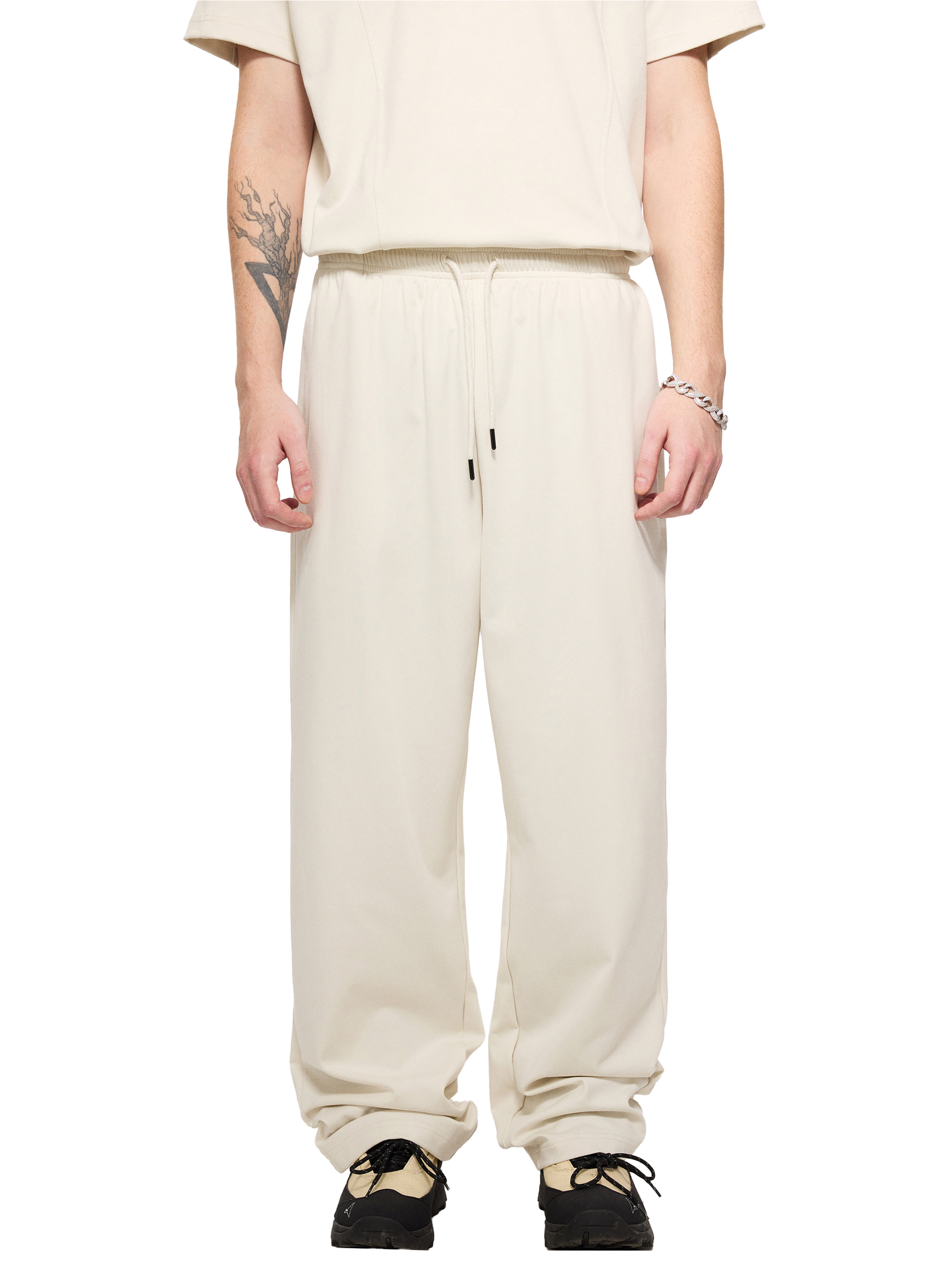 Lower half of a male model wearing a sustainable 240 GSM Future-Homme activewear mesh lined quick dry performance pants in grayish white front angle on a white background
