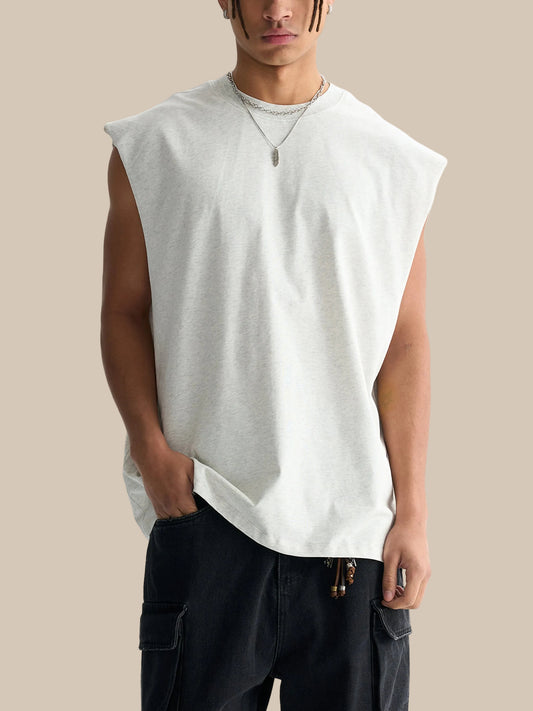 Man wearing a sleeveless white shirt and black pants on a white background