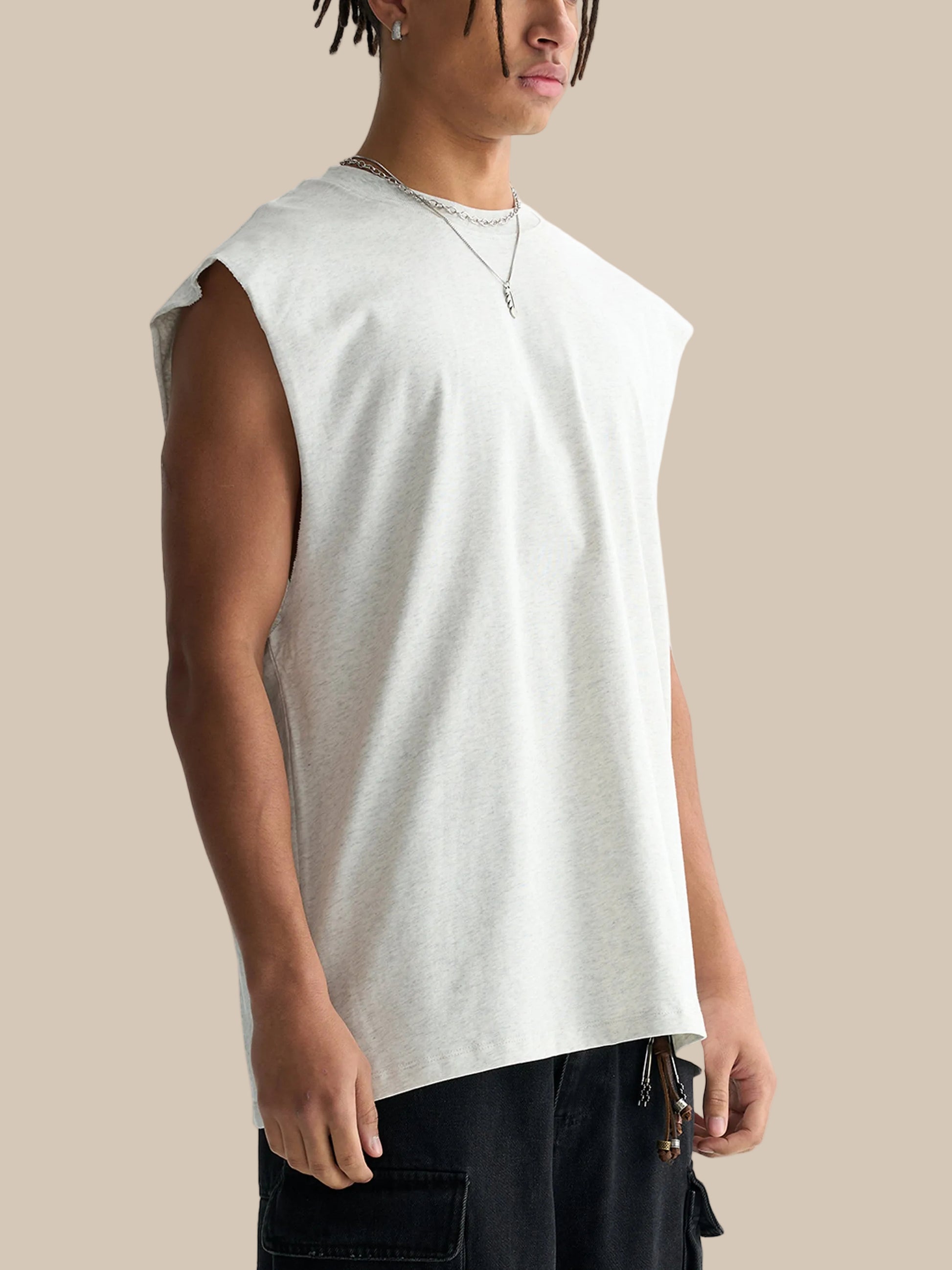 Person wearing a plain white sleeveless shirt on a white background