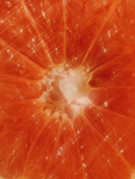 Close-up of a sliced grapefruit showing juicy interior and fibrous texture.