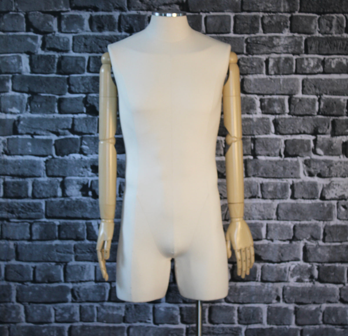 A Future-Homme male bust form covered in cream linen with wood arms against a gray background for the Worn Yesterday category. 