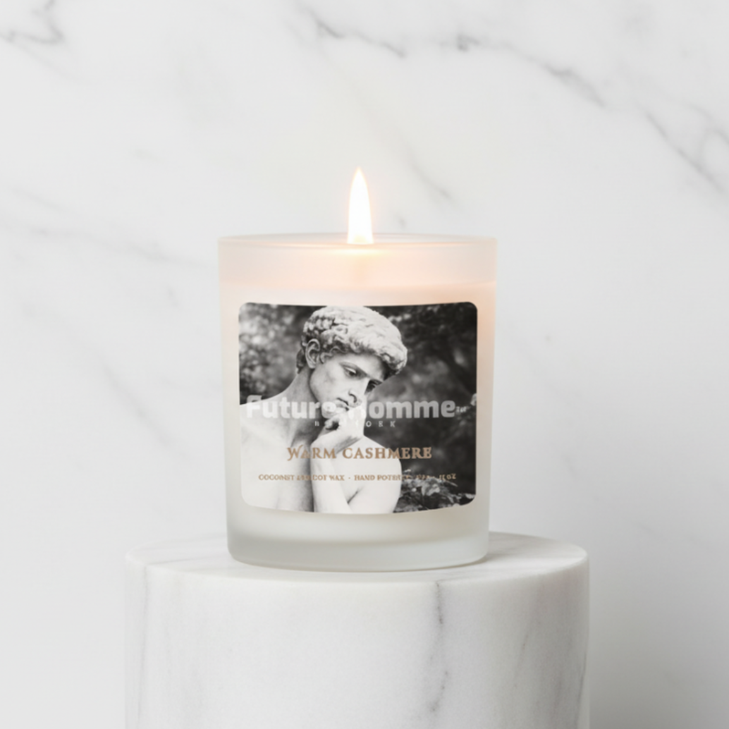 Candle with a label featuring a black and white image of a man on a marble surface.