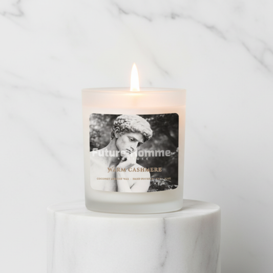 Candle with a label featuring a black and white image of a man on a marble surface.