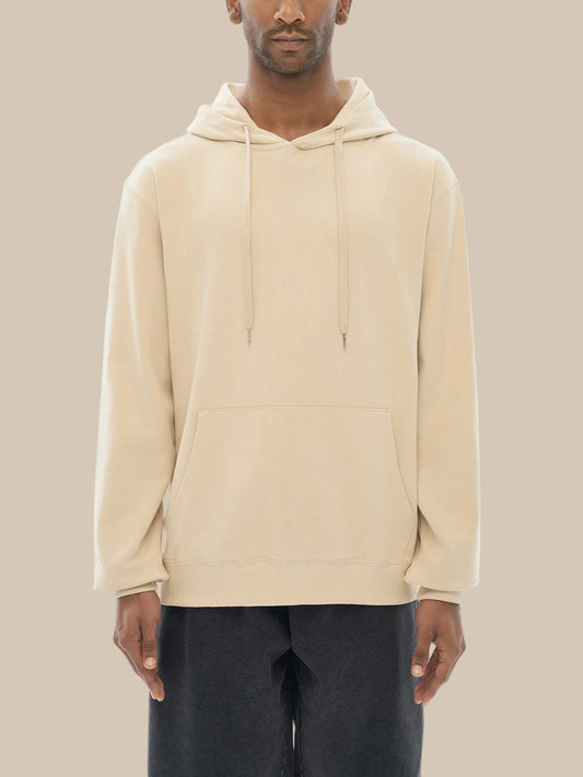 Model wearing the sustainable Future-Homme daily uniform classic cotton hoodie in apricot frontside angle on a white background 