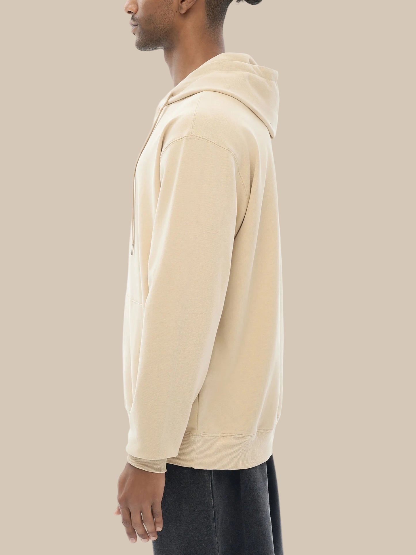 Beige hoodie worn by a person on a white background