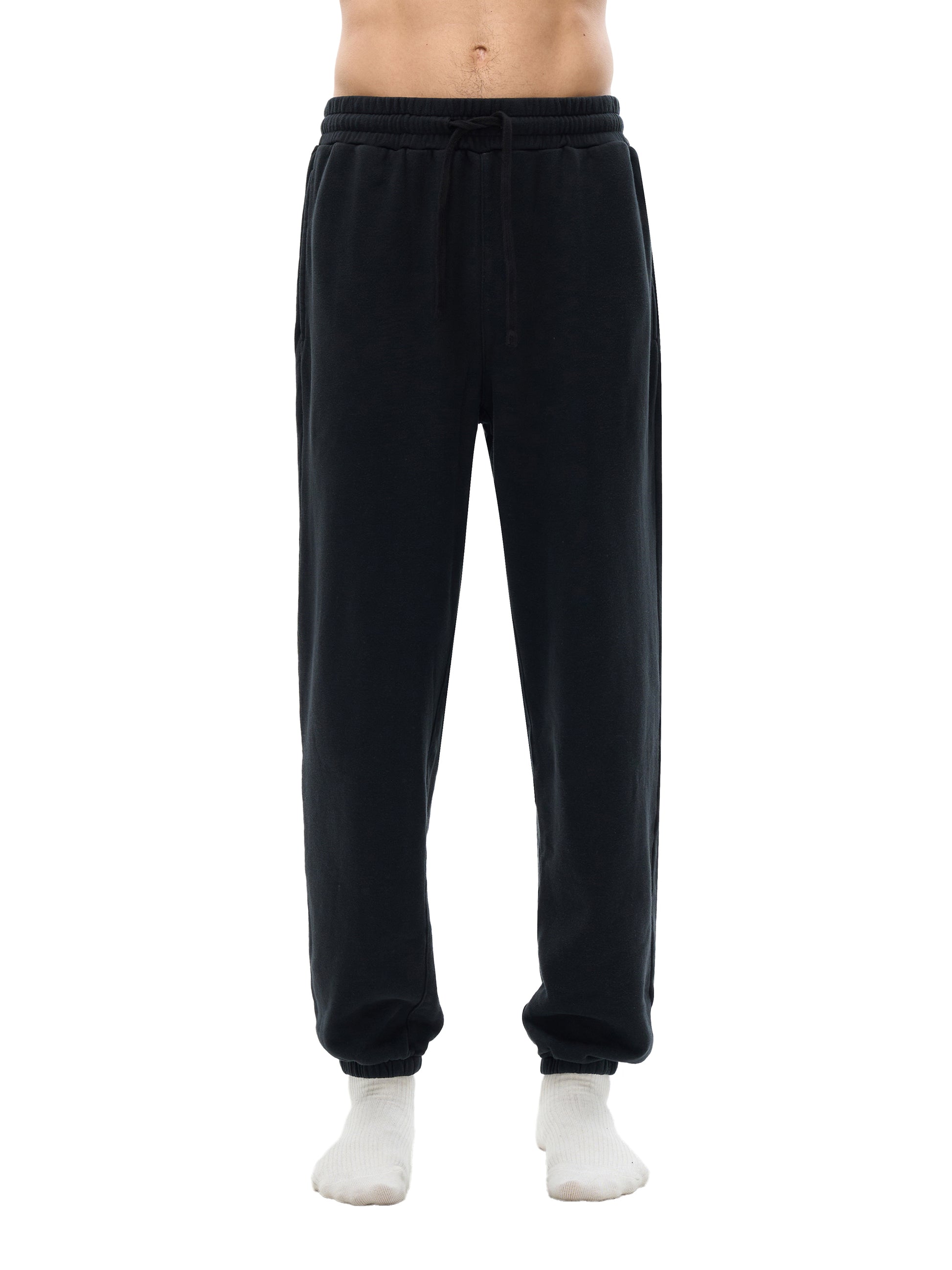 Lower half of model wearing sustainable 360 GSM Future-Homme daily uniform cotton fleece sweatpants forward facing in black on a white background. 