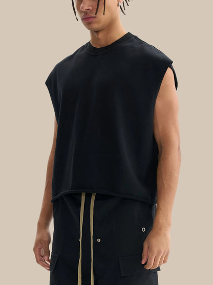 Person wearing a black sleeveless shirt and black pants on a white background