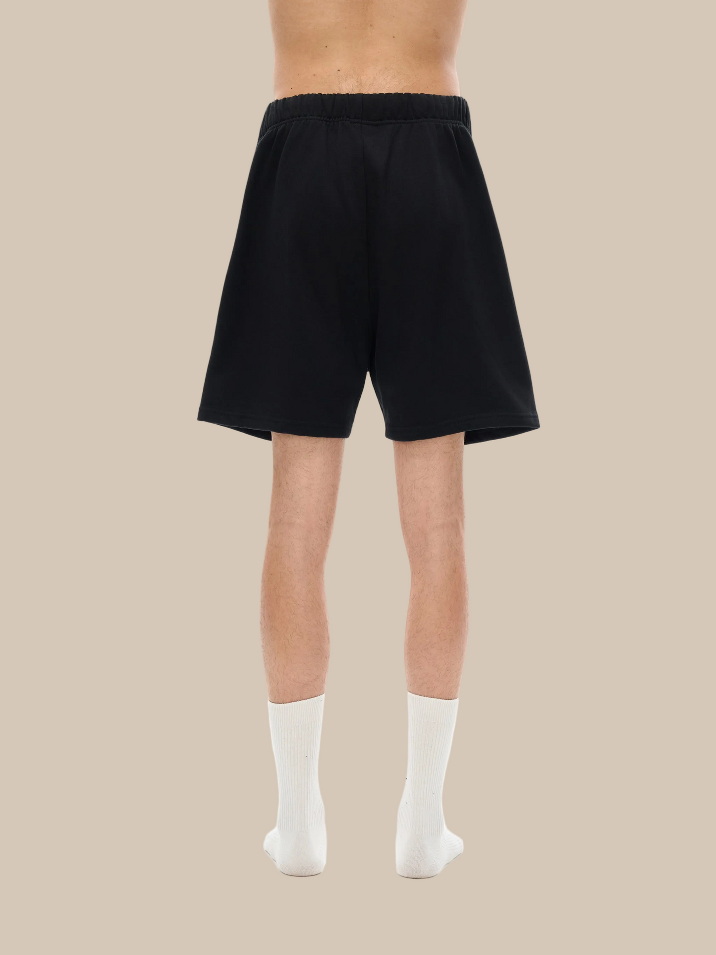 Person wearing black shorts on a white background