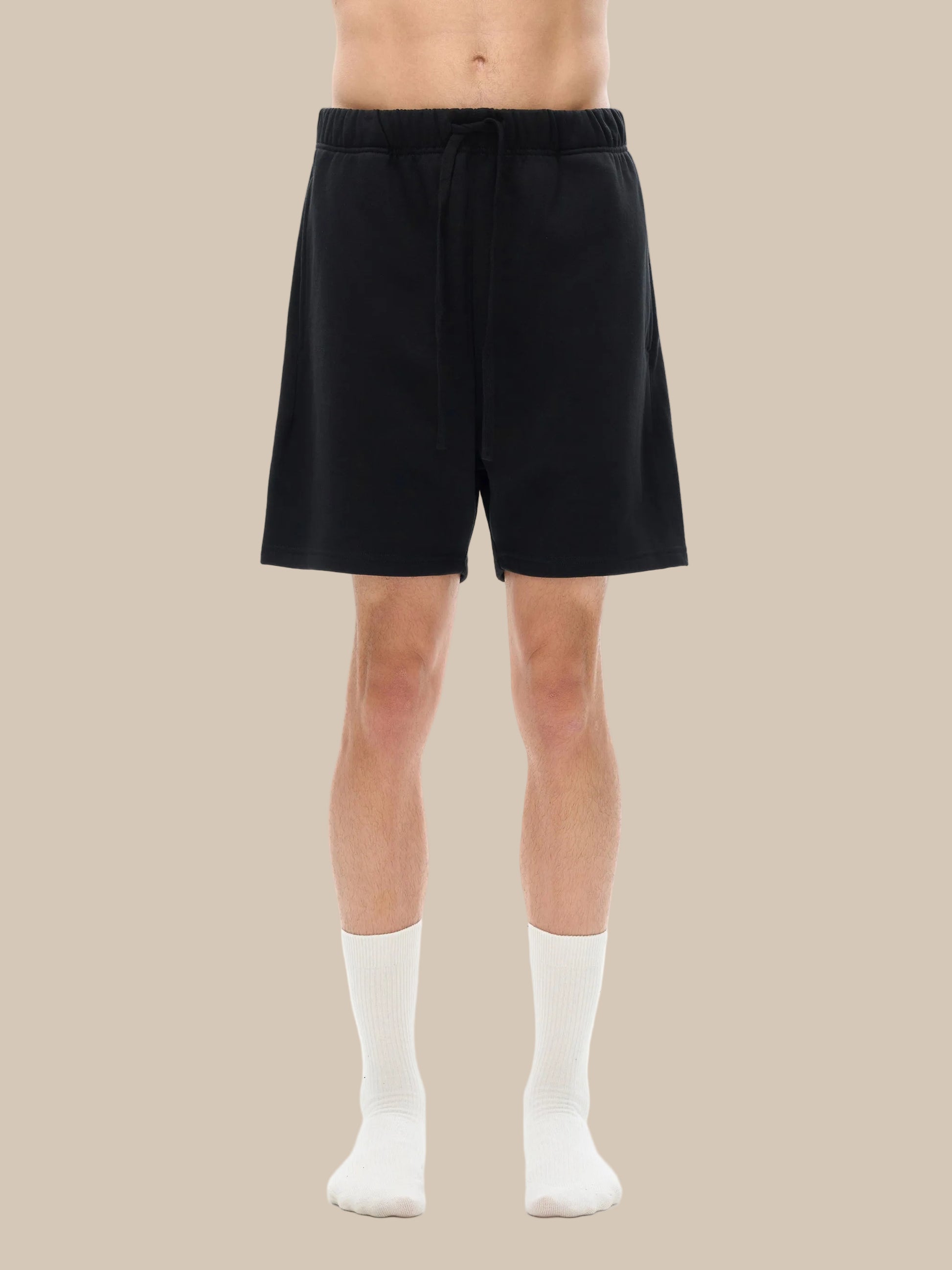 Person wearing black shorts on a white background