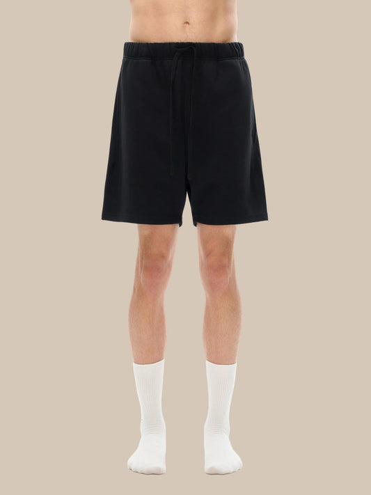 Person wearing black shorts on a white background