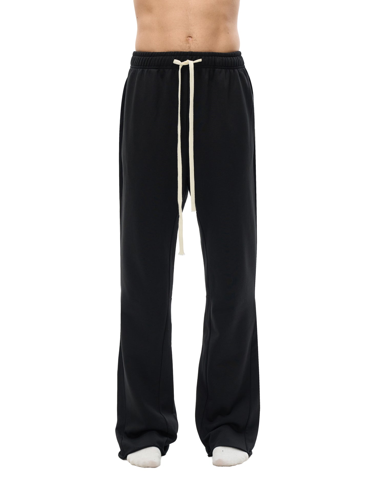 Lower half of model wearing the sustainable 420 GSM Future-Homme daily uniform mid rise flared cotton sweatpants in black front view on a white background