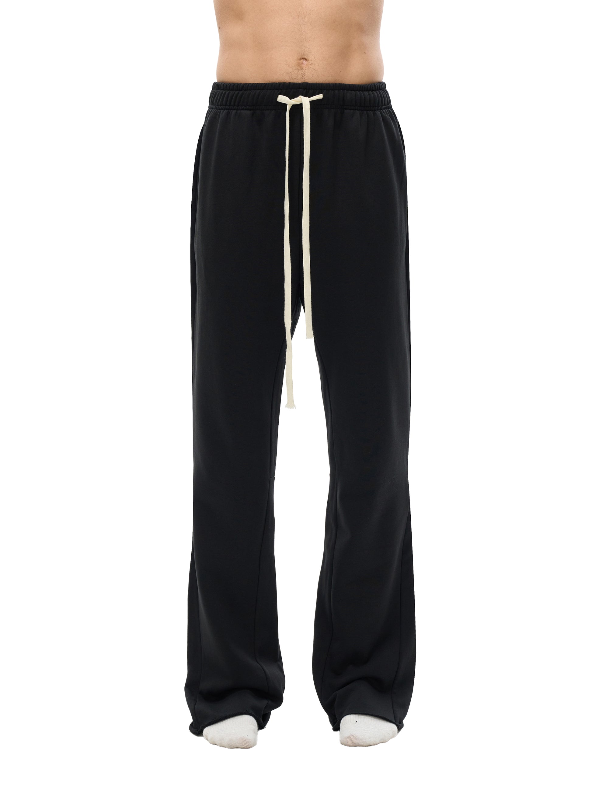 Lower half of model wearing the sustainable 420 GSM Future-Homme daily uniform mid rise flared cotton sweatpants in black front view on a white background