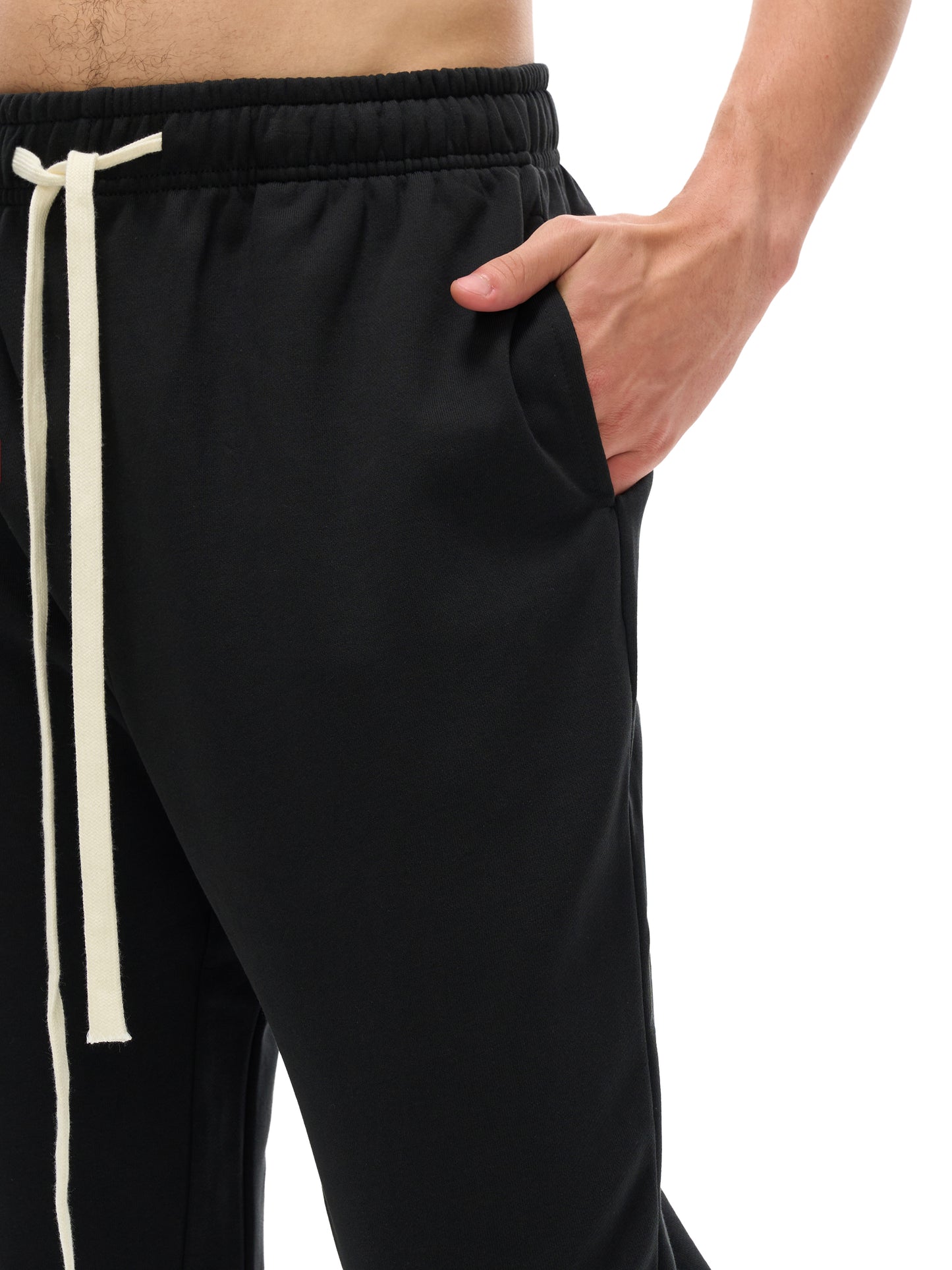 Lower half of model wearing the sustainable 420 GSM Future-Homme daily uniform mid rise flared cotton sweatpants in black front side pocket on a white background