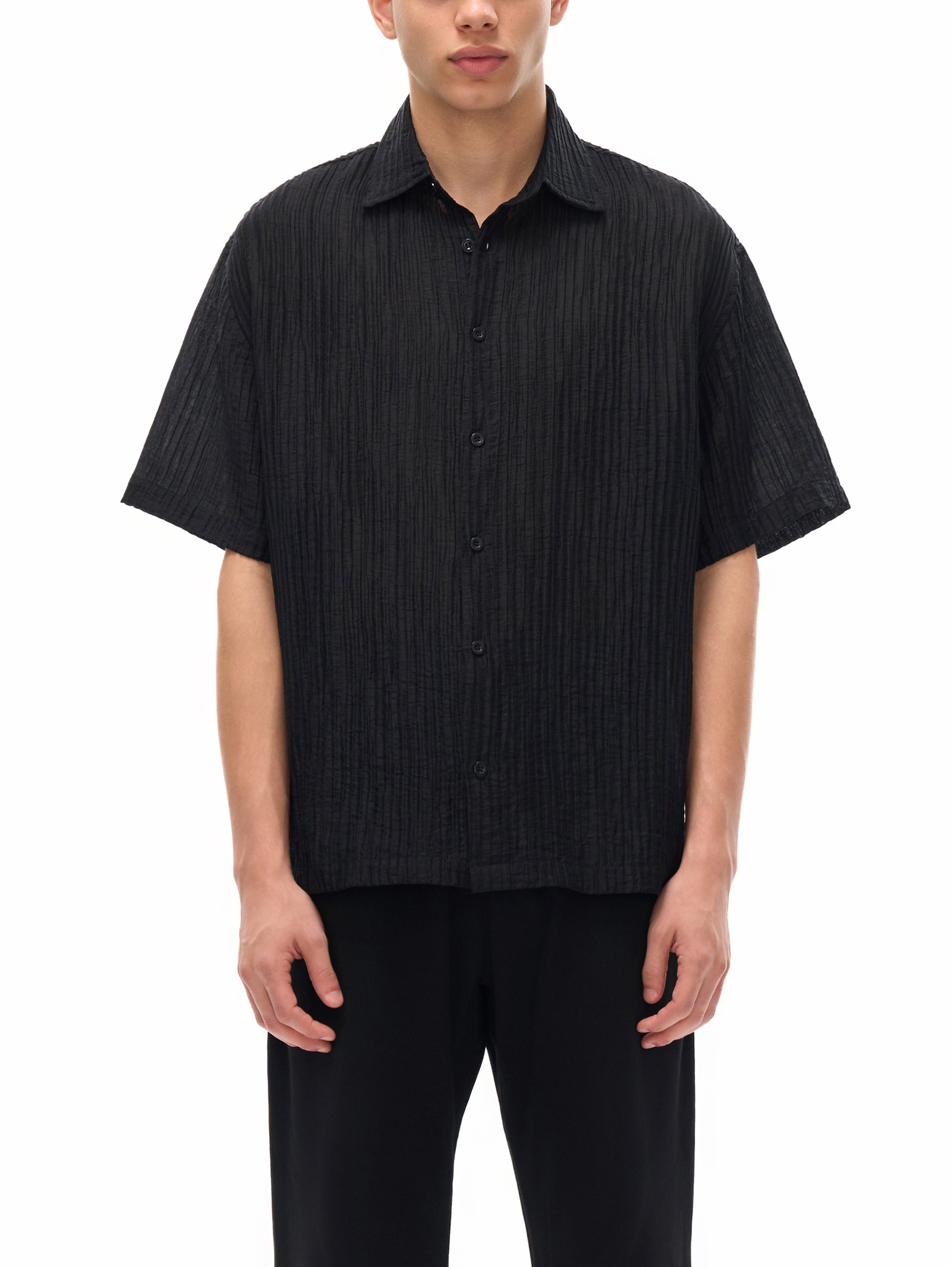 Model wearing the sustainable Future-Homme daily uniform, tencel jacquard button down in black frontside angle on a white background
