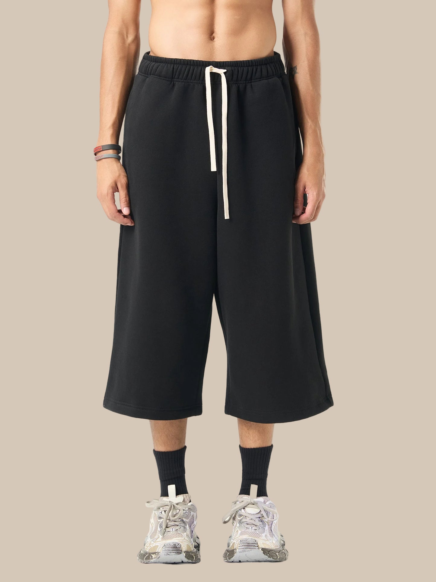 Person wearing black wide-leg pants with a white drawstring on a white background