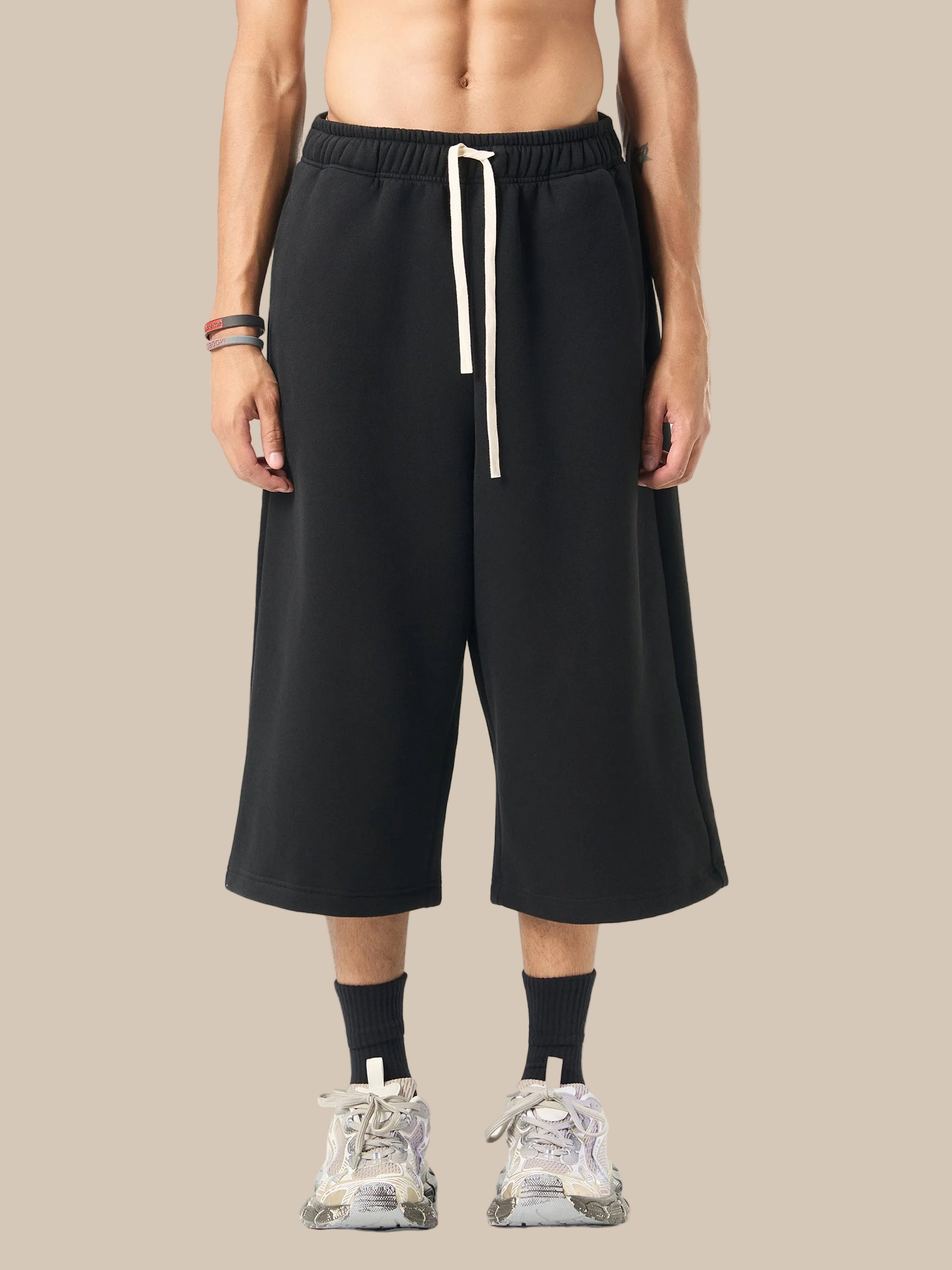 Person wearing black wide-leg pants with a white drawstring on a white background