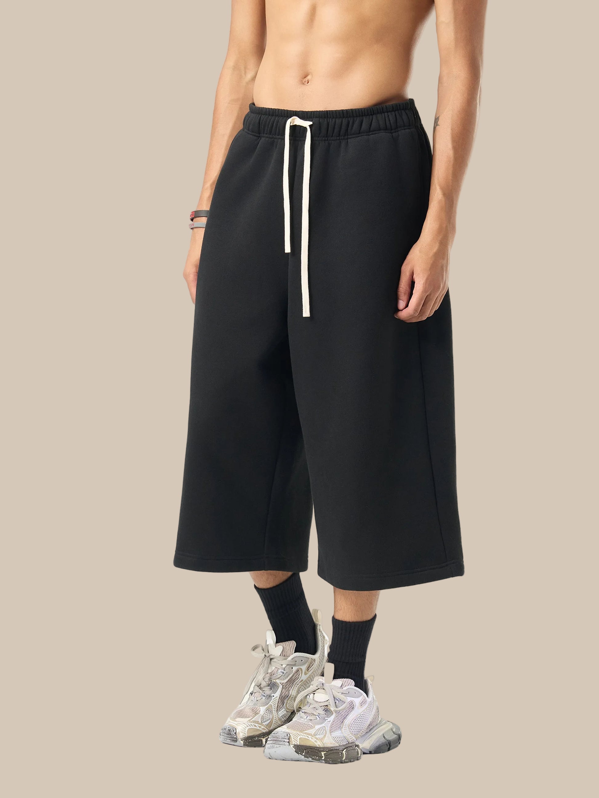 Person wearing black wide-leg pants with a white drawstring on a white background