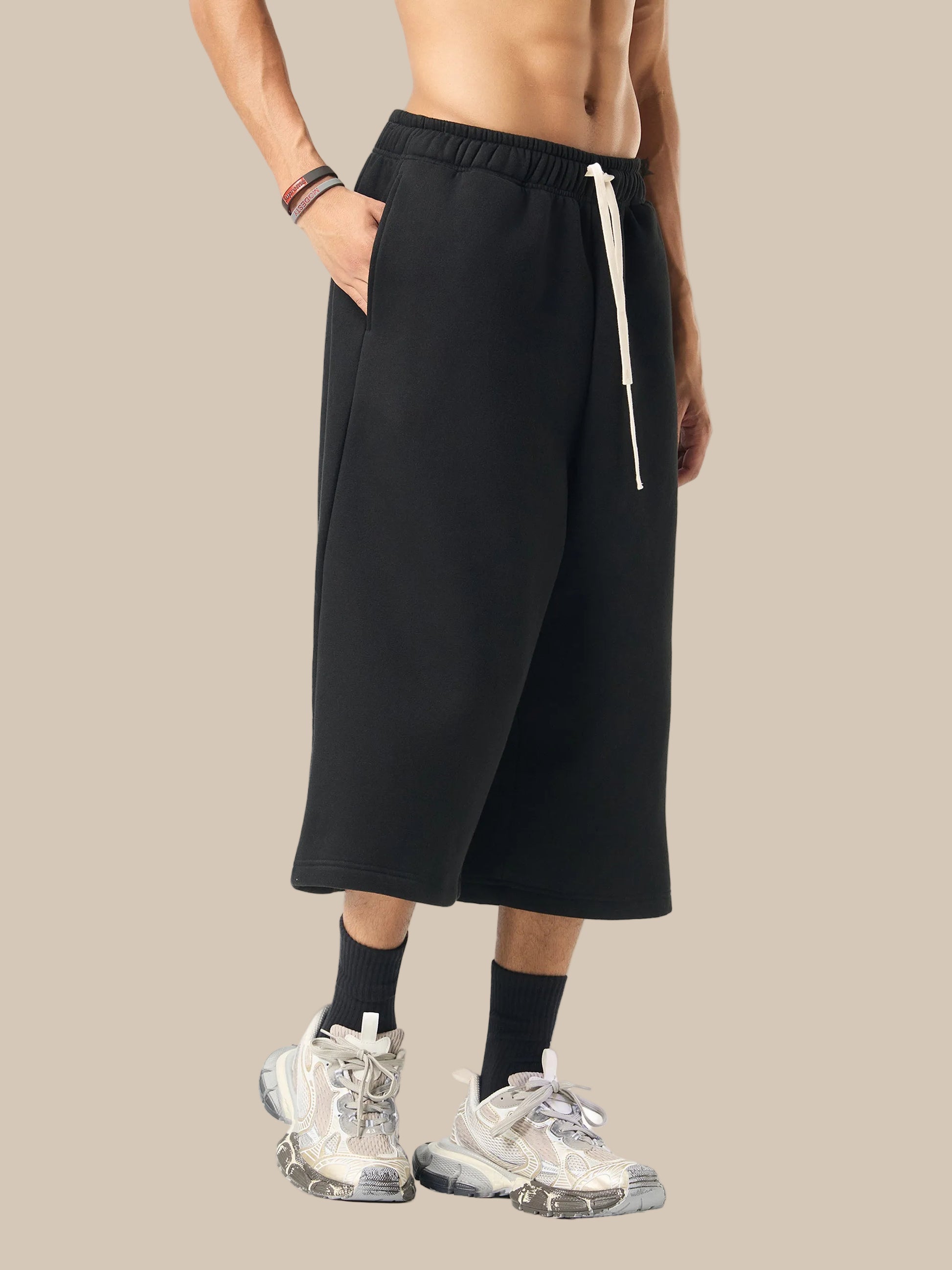 Person wearing black wide-leg pants with a white zipper on a white background