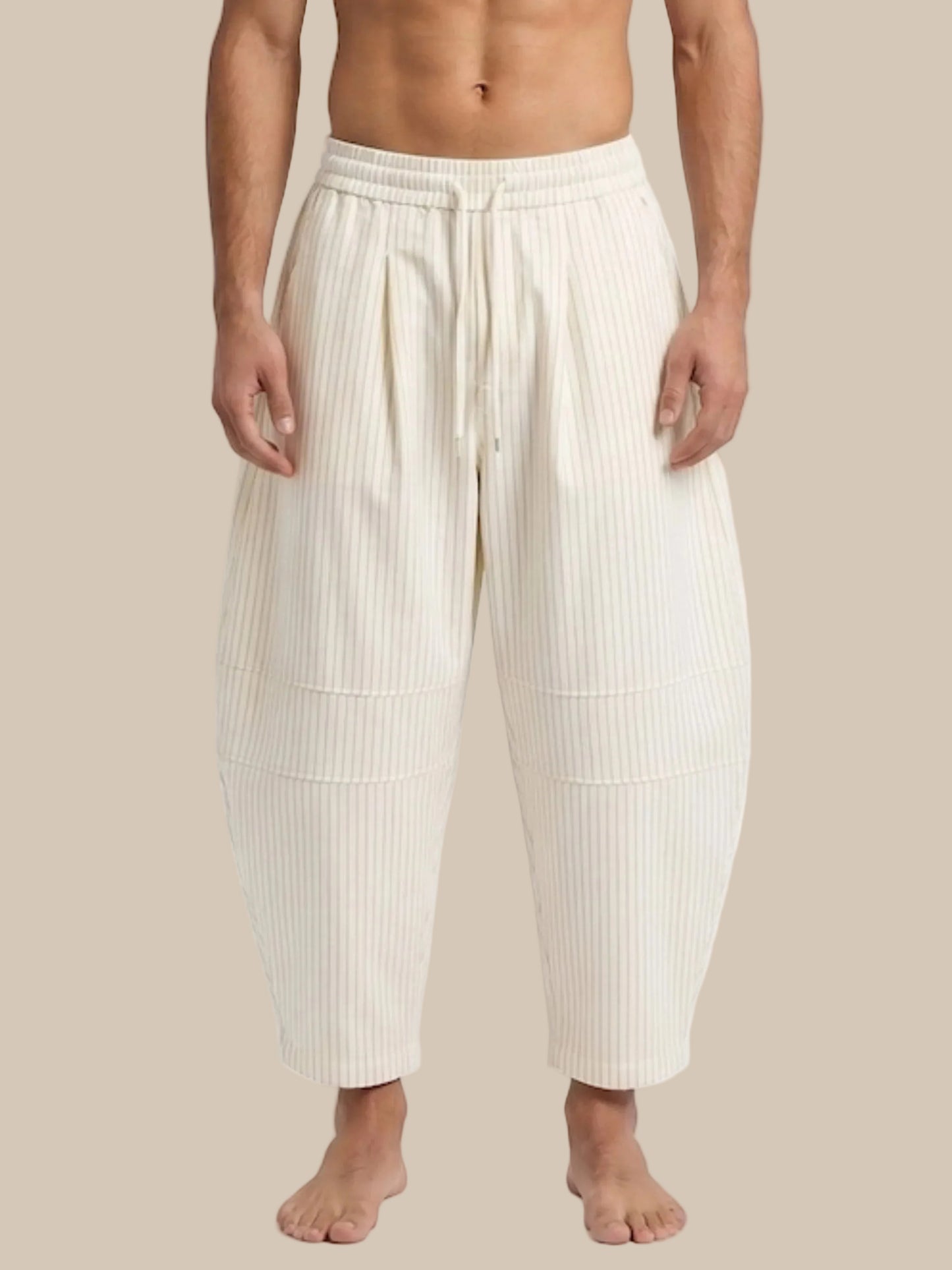 Person wearing cream-colored ribbed pants on a white background