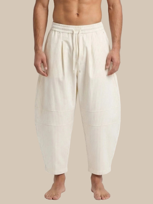 Person wearing cream-colored ribbed pants on a white background