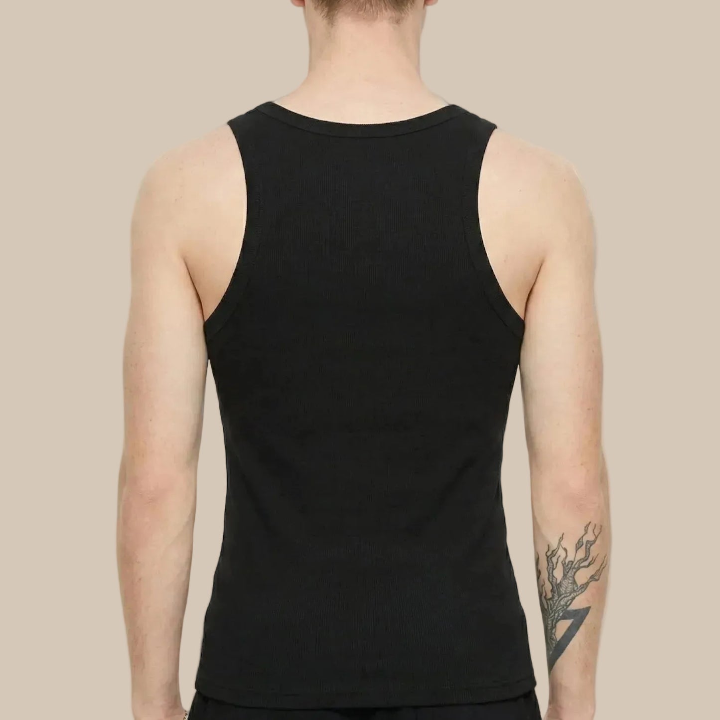 Person wearing a black tank top on a sand background