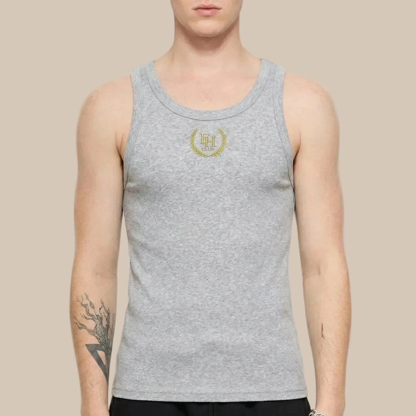 Person wearing a gray tank top with a logo on a ivory background