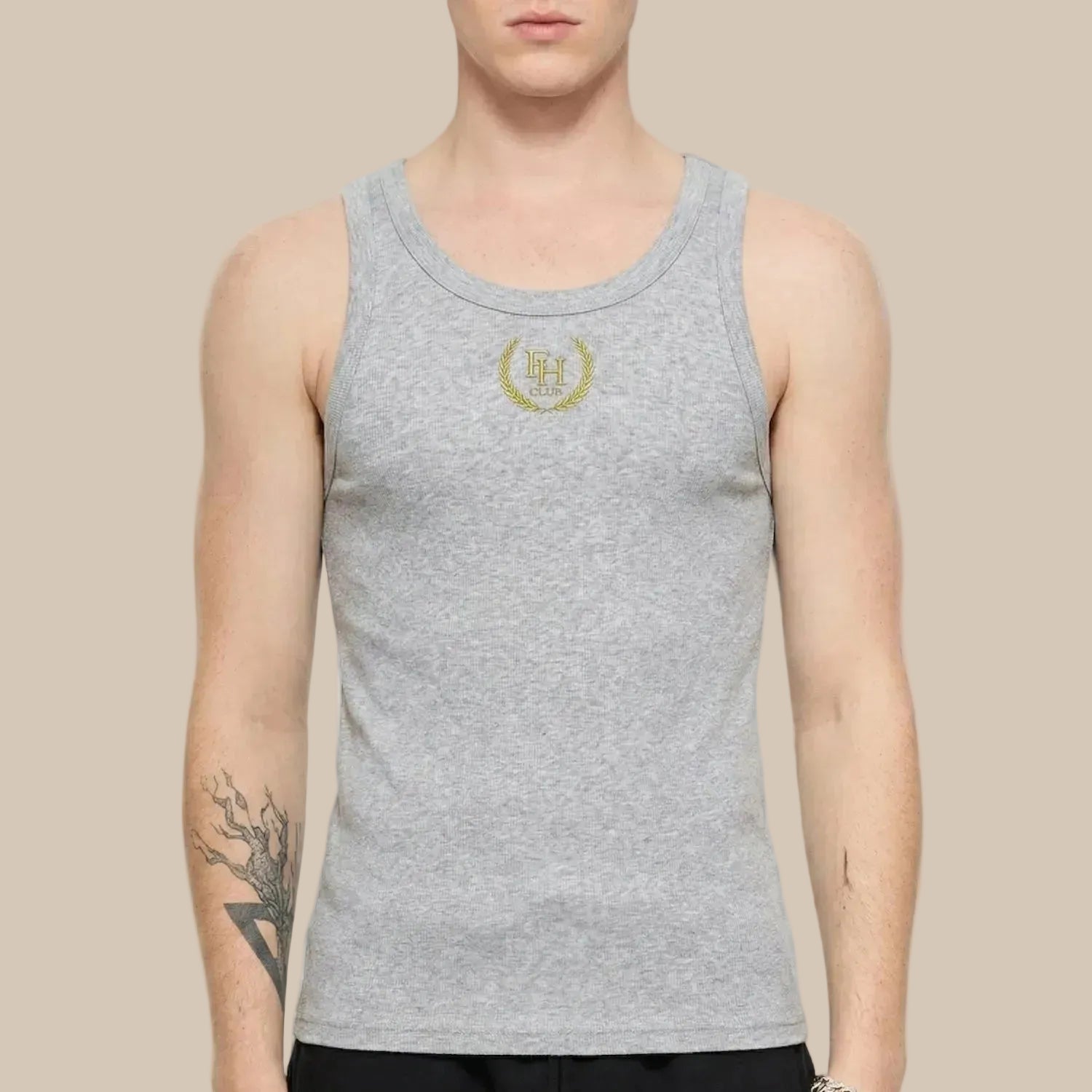 Person wearing a gray tank top with a logo on a ivory background