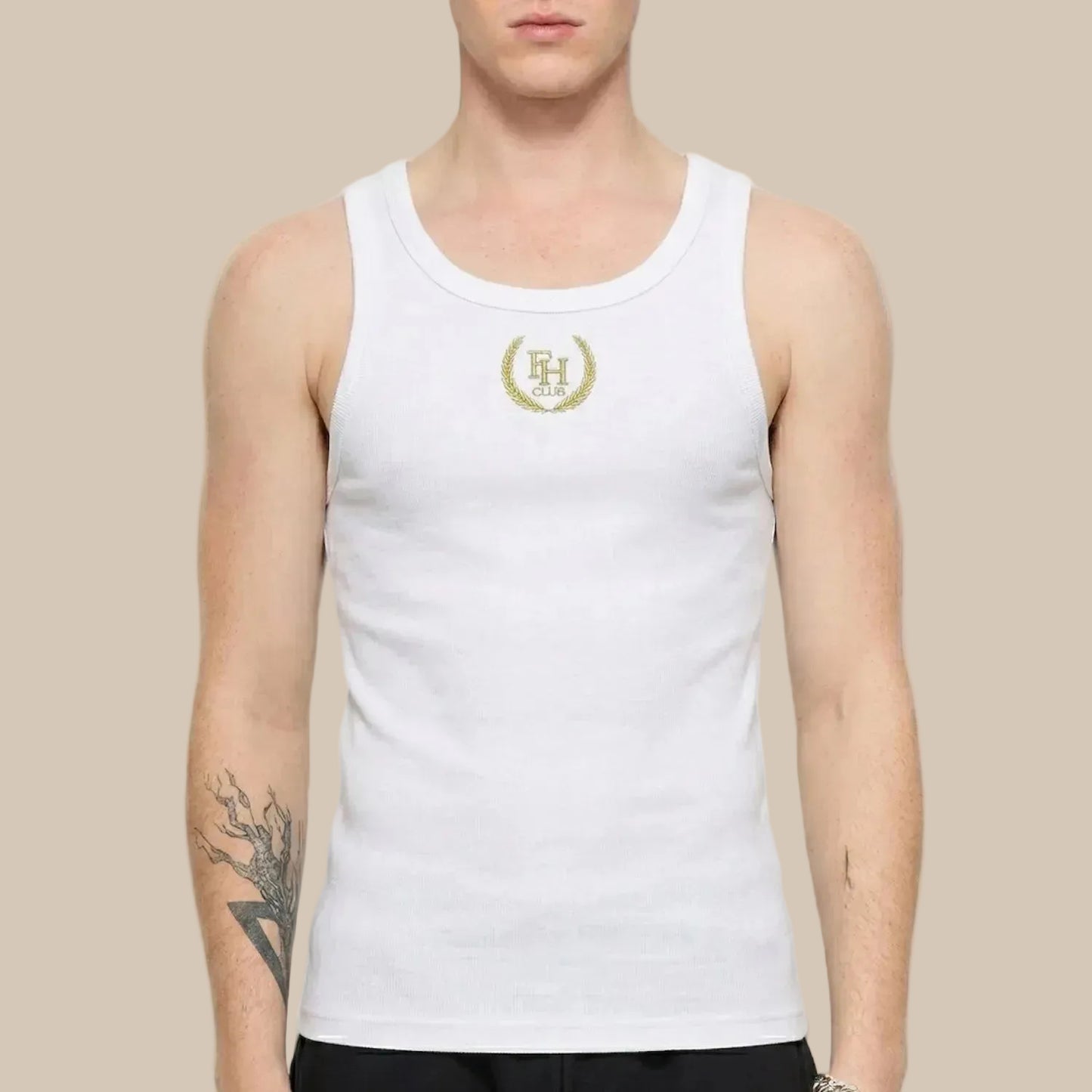 Person wearing a white tank top with a logo on a plain background